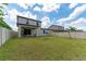 Spacious backyard with a large lawn, wooden swing set, and privacy fence at 5443 Carrara Ct, St Cloud, FL 34771