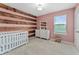 Bedroom with wood-paneled accent wall and crib at 5443 Carrara Ct, St Cloud, FL 34771