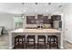 Modern kitchen with dark wood cabinets, granite countertops and island with seating at 5443 Carrara Ct, St Cloud, FL 34771