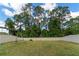 Large backyard with a grassy area, wooden swing set and a fence at 5443 Carrara Ct, St Cloud, FL 34771