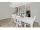 Open dining room with white table and chairs, view to kitchen at 5443 Carrara Ct, St Cloud, FL 34771