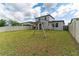 Backyard view showcasing a grassy lawn, swing set, and a partially visible house at 5443 Carrara Ct, St Cloud, FL 34771
