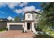 Two-story house with a gray exterior, dark gray garage door, and landscaped front yard at 5443 Carrara Ct, St Cloud, FL 34771