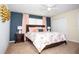 Main bedroom with floral bedding, dark-blue accent wall, and ceiling fan at 8954 California Palm Rd, Kissimmee, FL 34747