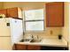 Kitchen with a double sink, wood cabinets, and a window at 125 Grand Junction Blvd, Orlando, FL 32835