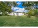 House with grassy backyard, mature trees, and a partially visible fence at 3703 Wade Rd, Orlando, FL 32808