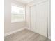 Simple bedroom with neutral walls, new flooring, and a double door closet at 3703 Wade Rd, Orlando, FL 32808