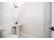 Clean bathroom with pedestal sink and marble-look wall tiles at 3703 Wade Rd, Orlando, FL 32808