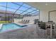 Screened pool area with lounge chairs, dining table, and grill at 4306 Lana Ave, Davenport, FL 33897