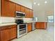 Modern kitchen with stainless steel appliances and wood cabinets at 218 Cattail Way, Lake Alfred, FL 33850