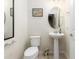 Small bathroom with pedestal sink, toilet and oval mirror at 5128 Caspian St, St Cloud, FL 34771