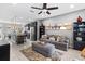 Open living room and kitchen with island, gray sofa, and ceiling fan at 5128 Caspian St, St Cloud, FL 34771