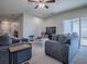 Open living space with gray sectional sofa and sliding glass doors at 911 Avenal, Davenport, FL 33837