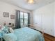 Bright bedroom with a queen bed, window, and wood floors at 941 Rimini Dr, St Cloud, FL 34771
