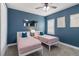 Two twin beds in a blue-walled bedroom with plantation shutters at 10159 Royal Island Ct, Orlando, FL 32836
