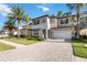 Two-story house with gray and white exterior, a dark door, and a brick driveway at 10159 Royal Island Ct, Orlando, FL 32836