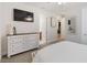 Bedroom with dresser, ensuite bath access, and large TV at 10159 Royal Island Ct, Orlando, FL 32836