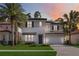 Two-story house with gray and white exterior, a dark door, and a brick driveway at 10159 Royal Island Ct, Orlando, FL 32836