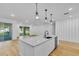 Bright kitchen features a large island, white cabinets, and hardwood floors at 155 Pearl St, Auburndale, FL 33823