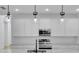 White kitchen with stainless steel appliances and modern light fixtures at 155 Pearl St, Auburndale, FL 33823