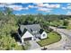 Aerial view of a modern farmhouse on a tree-lined street at 155 Pearl St, Auburndale, FL 33823