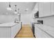 Modern kitchen with white cabinets, quartz countertops, and stainless steel appliances at 155 Pearl St, Auburndale, FL 33823