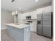 Modern kitchen with white cabinets, gray island, stainless steel appliances, and quartz countertops at 1877 Snapper Dr, Kissimmee, FL 34759