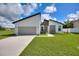 Modern, single-story home with a two-car garage and well-manicured lawn at 1877 Snapper Dr, Kissimmee, FL 34759