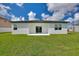 White house with covered patio and grassy lawn at 1877 Snapper Dr, Kissimmee, FL 34759