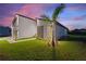Modern home exterior at dusk, showcasing landscaping and architectural details at 1877 Snapper Dr, Kissimmee, FL 34759