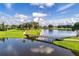 Aerial view of a golf course community with a lake and bridge at 2108 Drive Way, Kissimmee, FL 34746