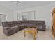 Spacious living room featuring a large sectional sofa and a wooden coffee table at 21523 Queen Anne Ct, Leesburg, FL 34748