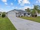 Single-story home with attached two-car garage and landscaped lawn at 21523 Queen Anne Ct, Leesburg, FL 34748