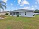 View of home exterior with a large grassy backyard at 21523 Queen Anne Ct, Leesburg, FL 34748