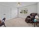 Bedroom with a massaging chair, double doors, and a window at 21523 Queen Anne Ct, Leesburg, FL 34748