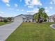 Single-story home with attached two-car garage and landscaped lawn at 21523 Queen Anne Ct, Leesburg, FL 34748