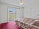 Bedroom with sliding door to patio, ceiling fan and striped bedding at 21523 Queen Anne Ct, Leesburg, FL 34748