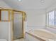 Bathroom with a shower and bathtub, updated vanity, and window at 21523 Queen Anne Ct, Leesburg, FL 34748