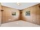 Bedroom with wood paneling, two windows, and wall shelving at 2900 Lake Arnold Pl, Orlando, FL 32806