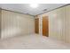 Bedroom with wood paneling, two closets, and neutral carpet at 2900 Lake Arnold Pl, Orlando, FL 32806