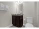 Single vanity bathroom with toilet and dark cabinets at 365 Southfield St, Kissimmee, FL 34747