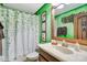 Bathroom with green walls and wooden accents at 1430 Thunderbird Rd, Davenport, FL 33896