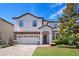 Two-story house with a light-colored facade and landscaping at 1430 Thunderbird Rd, Davenport, FL 33896