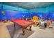 Fun game room with pool table, foosball, and ocean theme at 1430 Thunderbird Rd, Davenport, FL 33896