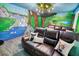 Cozy theater room with a nature-themed mural and leather seating at 1430 Thunderbird Rd, Davenport, FL 33896