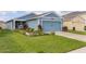 Newly built home with blue siding, two-car garage, and manicured lawn at 1944 Traverse Way, Kissimmee, FL 34746