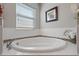 Relaxing bathroom with corner soaking tub, tile surround, and window at 4204 Oakview Dr, Davenport, FL 33837
