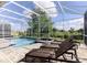 Spacious pool area with lounge chairs and a screened enclosure at 8843 Interlocking Ct, Davenport, FL 33896