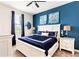 Bedroom with a white bed frame, blue bedding, and nautical-themed art at 8843 Interlocking Ct, Davenport, FL 33896