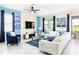 Spacious living area with white sectional sofa, blue accents, and large TV at 8843 Interlocking Ct, Davenport, FL 33896